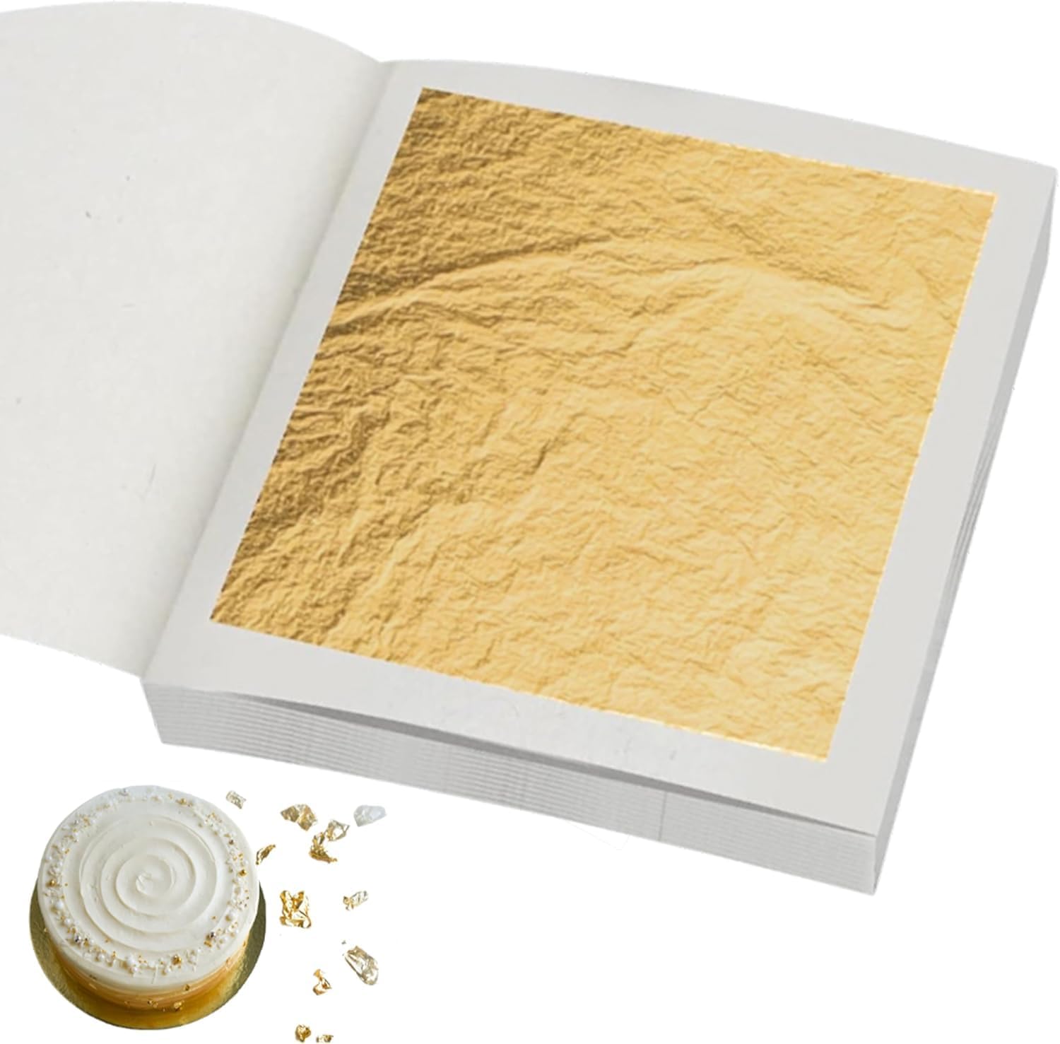 Open booklet of edible gold leaf sheets beside a small iced cake decorated with gold flakes